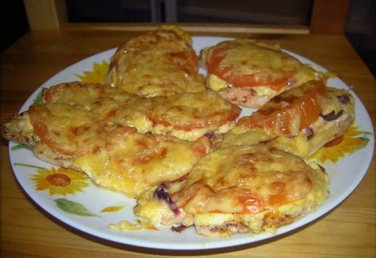 Chicken chops in a pan with tomatoes and cheese