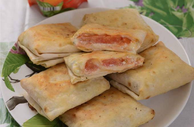 Lavash breakfast with tomato, cheese and egg in a pan