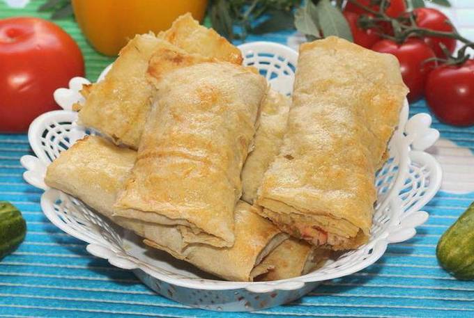 Lavash envelopes with ham, tomatoes and cheese in a pan