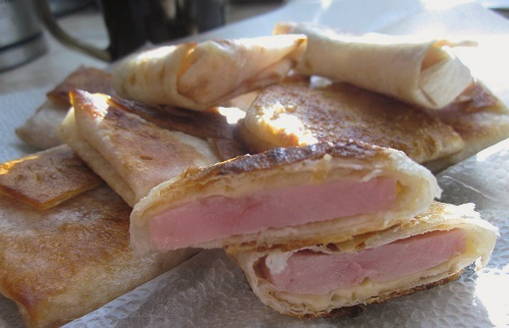 Lavash envelopes with ham and cheese in a pan