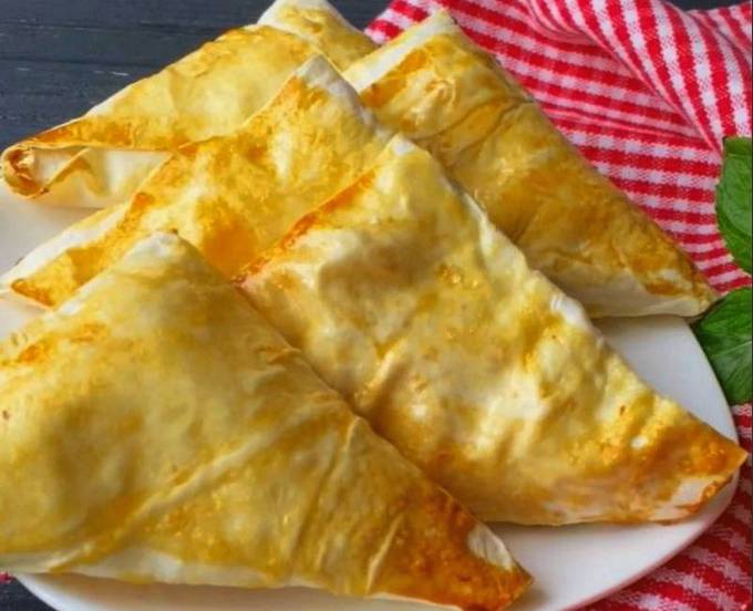 Lavash envelopes with cottage cheese and banana in a pan