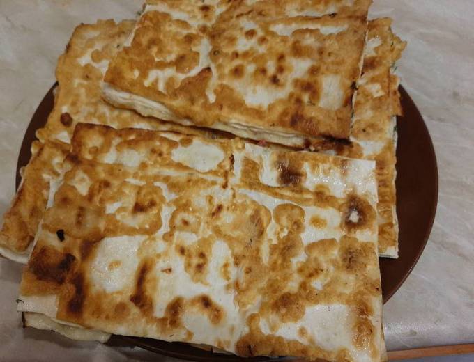 Lavash envelopes with sausage, cheese and egg in a pan