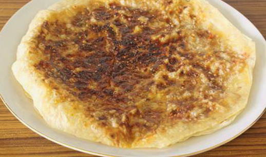 Pita bread with cheese and sausage in a pan