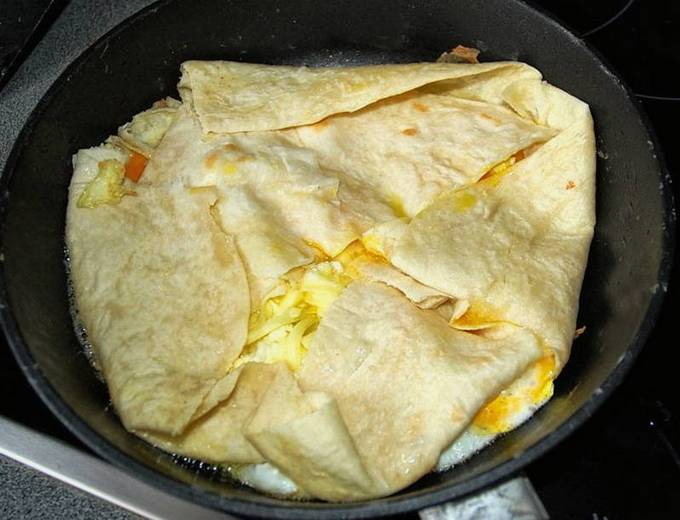 Lavash with sausage, cheese and egg in a pan