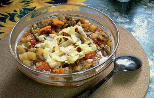 Lagman with chicken on the fire in a cauldron