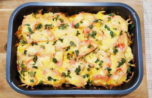 Potato casserole with chicken breast, cheese and tomatoes in the oven