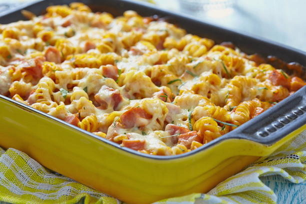 Pasta casserole with sausage, tomatoes and cheese in the oven