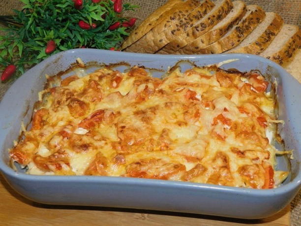 Potato casserole with chicken, cheese and tomatoes in the oven