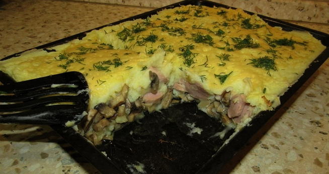 Casserole of potatoes, minced meat, mushrooms, tomatoes and cheese in the oven
