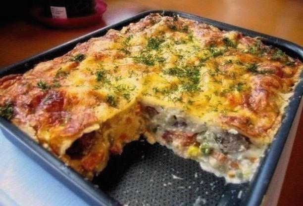 Potato casserole with minced meat, mushrooms, tomatoes and cheese in the oven