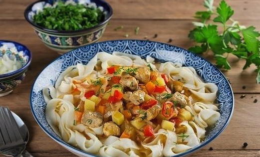 Pork lagman with noodles in a cauldron