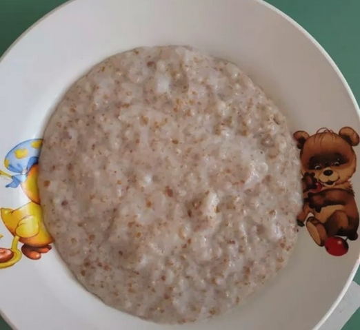 Wheat porridge with milk in a saucepan on the stove