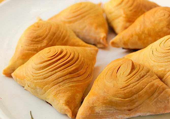 Samsa with minced puff yeast dough in the oven