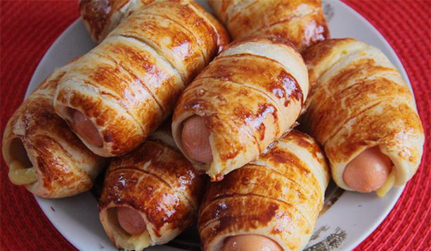 Sausages with cheese in puff pastry in the oven