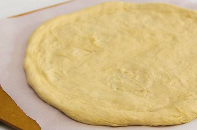 Dough with mayonnaise for pizza in the oven