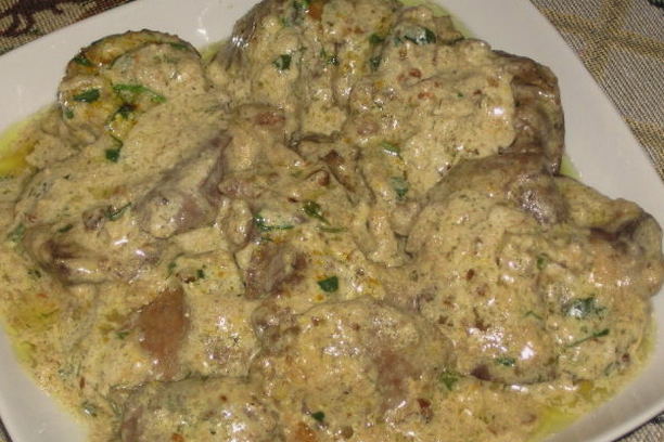 Chicken liver with mushrooms in sour cream sauce in a pan