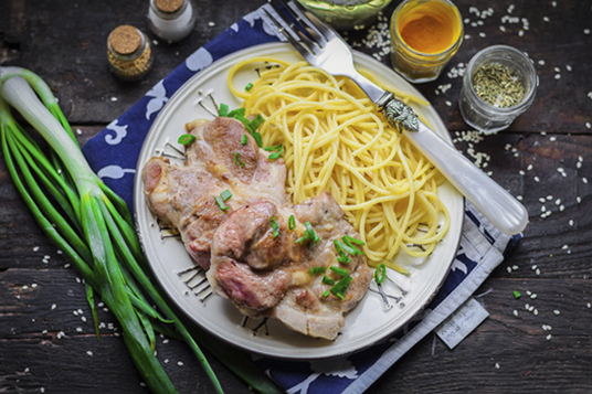 Pork neck in pieces in a pan