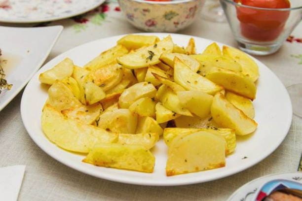 Potato wedges on parchment in the oven