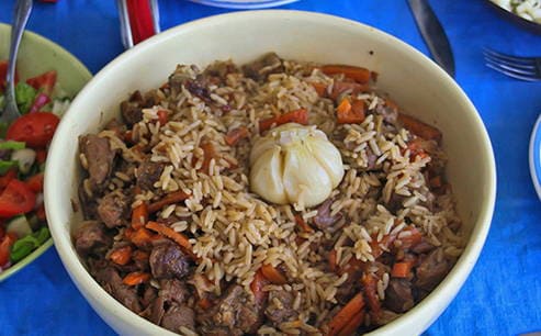 Pilaf from beef in a cauldron on gas