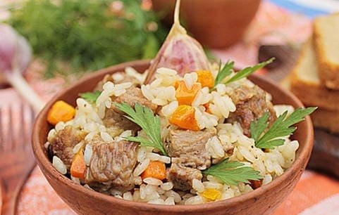 Pilaf with crumbly rice and beef in a pan