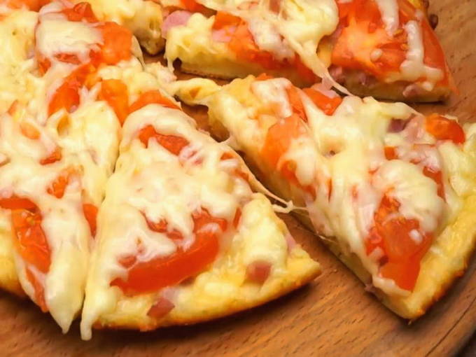 Fast pizza with sausage and cheese and tomatoes in a pan