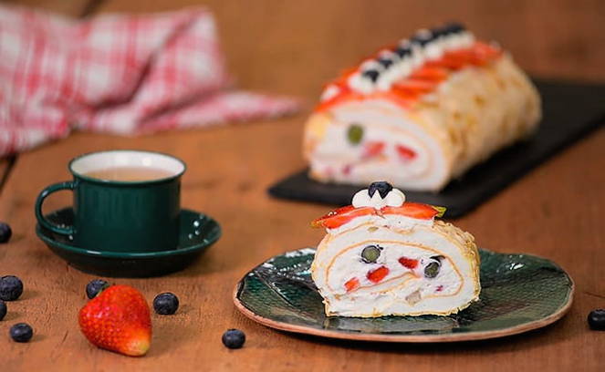 Meringue roll with strawberries and blueberries