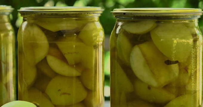 White apple compote pouring into a 3-liter jar for the winter